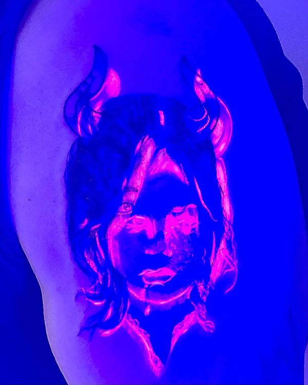 El retrato con cuernos bajo luz UV: fondo azul violeta y líneas rosas que brillan.